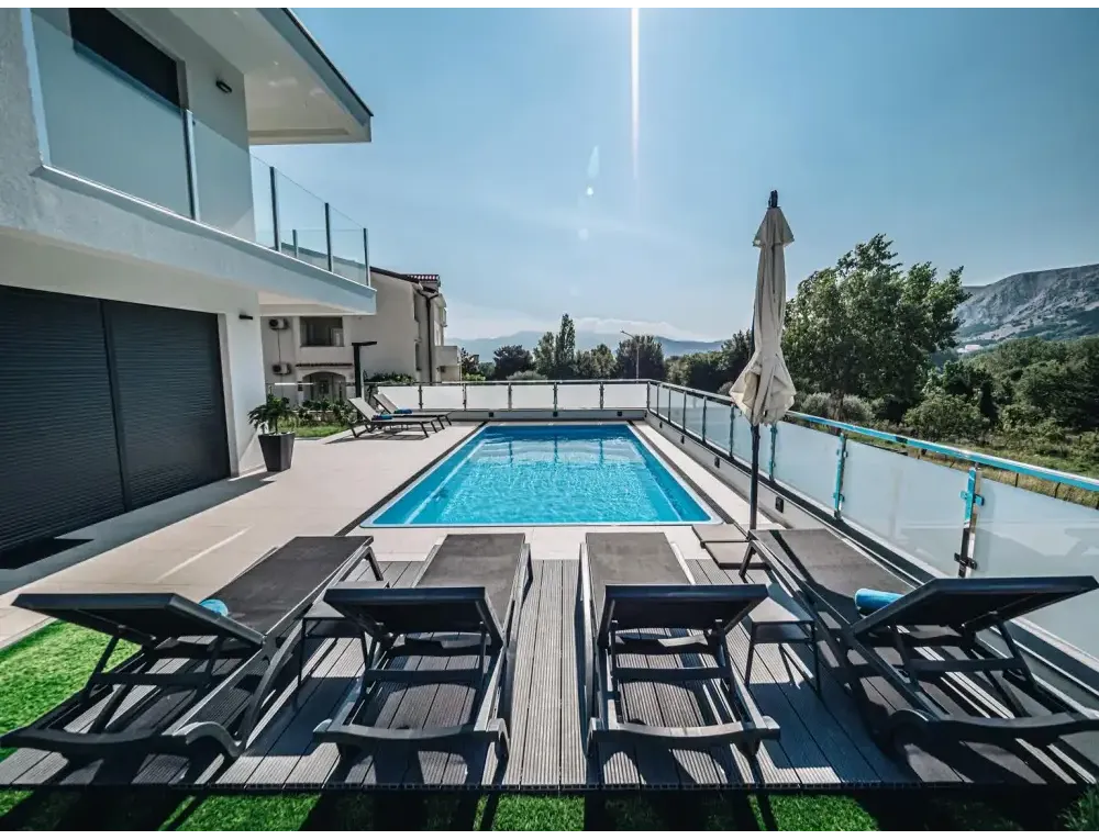 Rektangulär blå glasfiberpool Aruba med glasräcke och klart vatten